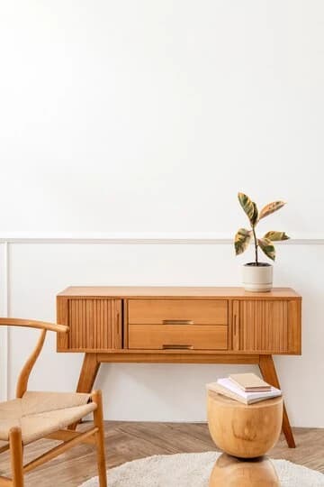 Houten dressoir in Scandinavische stijl met een plant en een gevlochten stoel